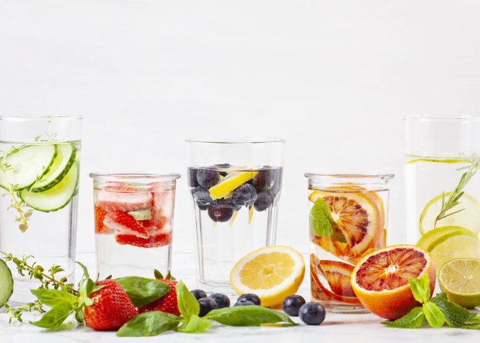 Variety of herbs and fruits flavored infused water and their ingridients. Summer refreshing drink. Health care, fitness, healthy nutrition diet concept.